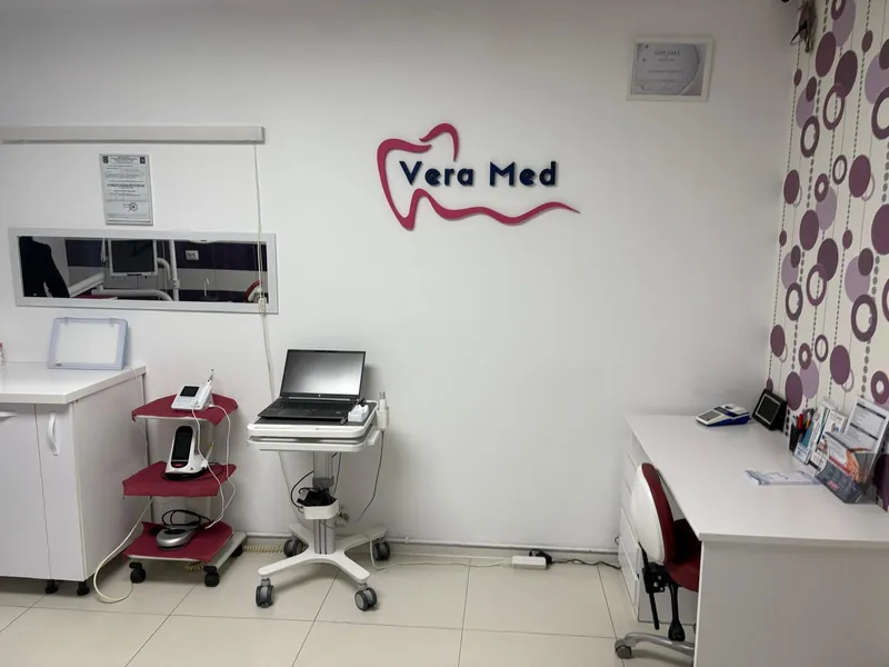 Cabinetul Vera Med: perete alb cu logo-ul Vera Med în relief și aparatura de lucru